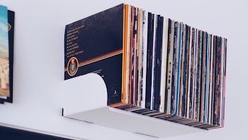 Assorted Book Hanging on White Painted Wall