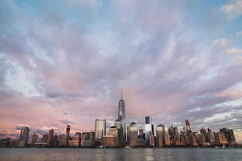 assorted buildings near body of water under cloudy sky