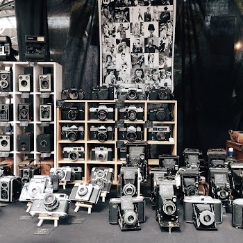 Assorted Cameras on Table and Racks