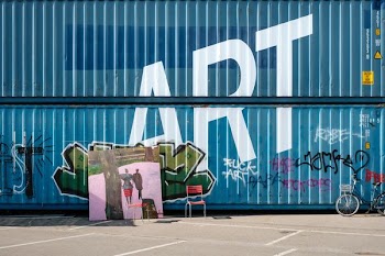 assorted-color graffiti on blue metal containers during daytime