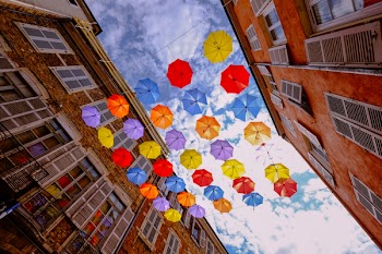Assorted-color Umbrellas Hanged Near Brown Building