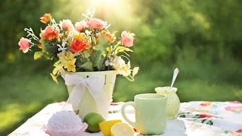 Assorted Flowers on Container Beside Mug on Table