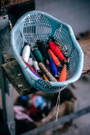 assorted spools of thread on basket