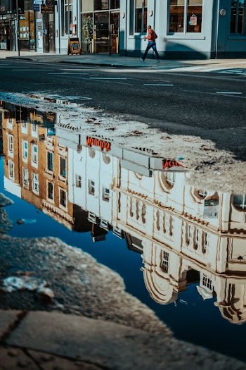 asymmetrical photo of brown and white concrete buildings on body of water