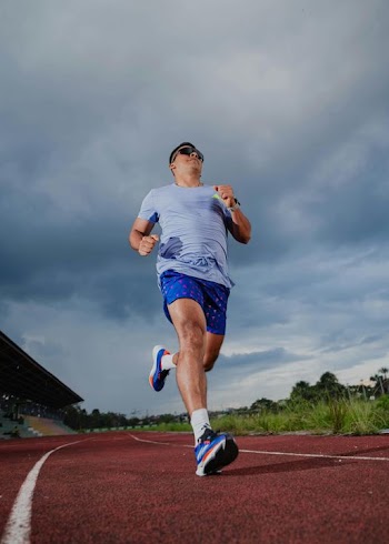 Athletic Man Running on Track during Cloudy Day