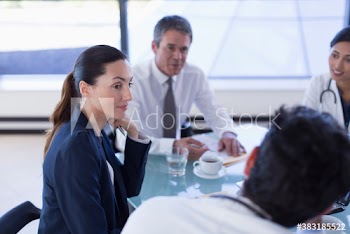 Attentive hospital administrator listening to doctors in meeting