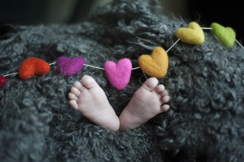 Baby's Feet Covered With Black Wool Textile