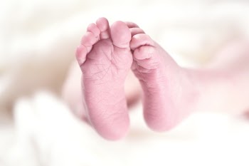 Baby's Foot on White Textile