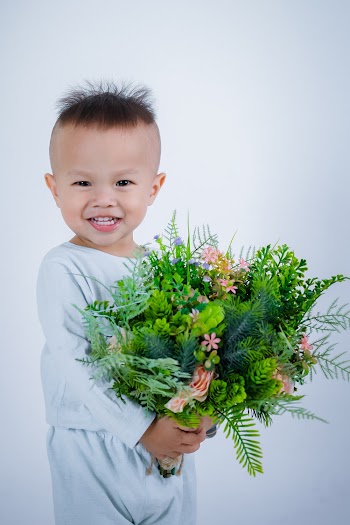 Baby Holding Fern Leaves