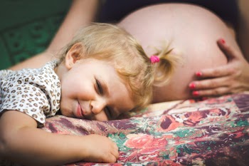 Baby Lying on Pregnant Woman's Lap