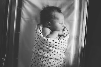baby rolled on white and black swaddle blanket