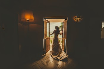 Back View Of A Woman Wearing Dress Standing On The Doorway Leading To A Balcony