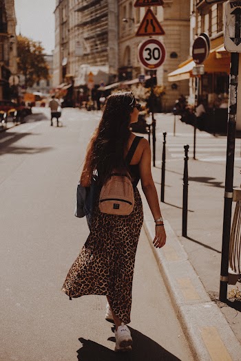 Back View of Woman Carrying Backpack Walking on Street
