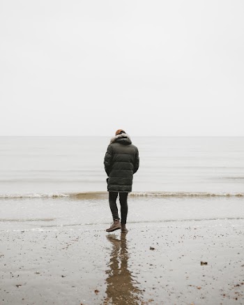 Back view Photo of Person Standing on Shore