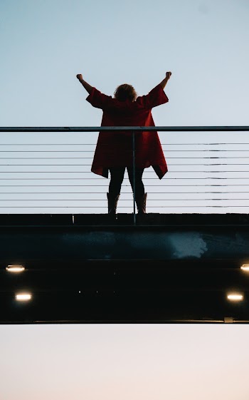 Back View Photo of Standing Woman with Her Hands Raised