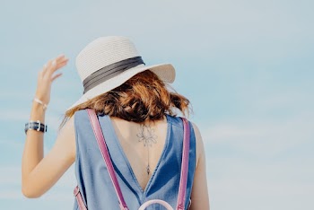 Back View Photo of Tattooed Woman Blue Sleeveless Dress and White Sun Hat 