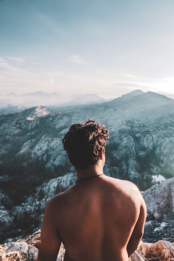 Back view Photo of Topless Man on Mountain Peak
