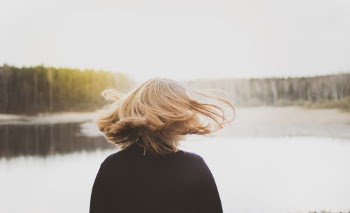 Back View Photo of Woman Flipping Her Hair While Looking at Lake