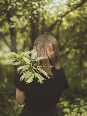 Back View Photo of Woman in Black T-shirt Holding Plant