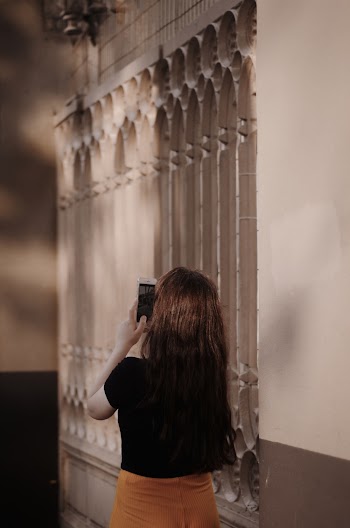 Back view photo of woman in black top using smartphone