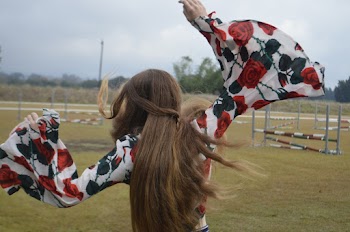 Back View Photo of Woman in Floral Top Posing With Her Hands Up