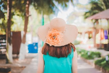 Back View Photo of Woman in Peach Sun Hat and Blue Top