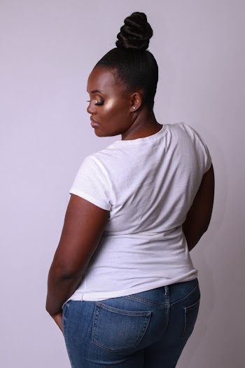 Back View Photo of Woman in White T-shirt and Blue Jeans Posing In Front of White Background