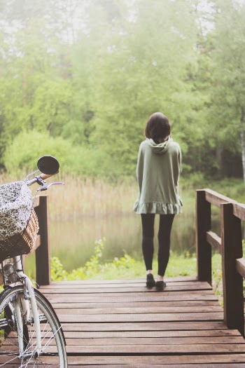 Back View Photo of Woman Standing on Dock 