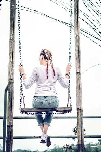 Back View Photo of Woman Swinging