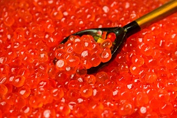 background from red caviar in wooden spoon