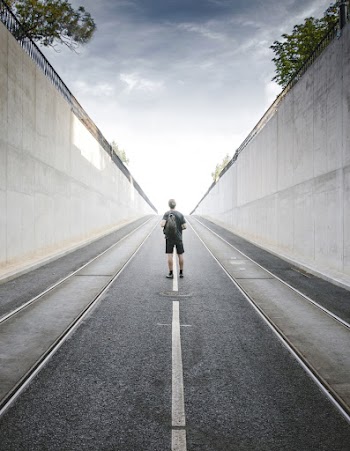 Backview of a man man standing in the middle of the road