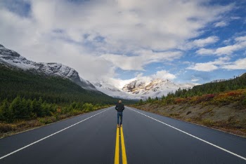 Backview Photo of Man Walking on Road