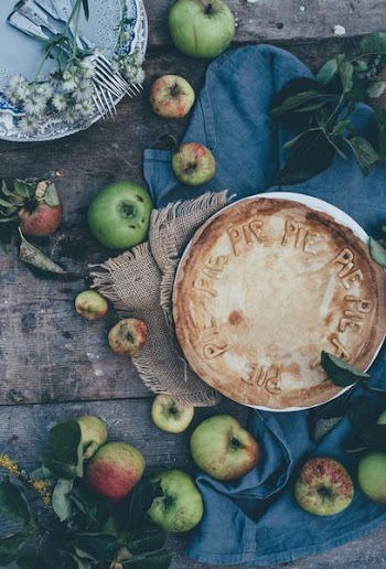 baked pie beside green apples