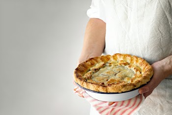 Baker holding a freshly baked cherry pie yummy dessert