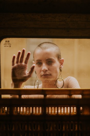 Bald Woman Touching Clear Glass Window