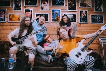 band taking groufie picture on brown sofa