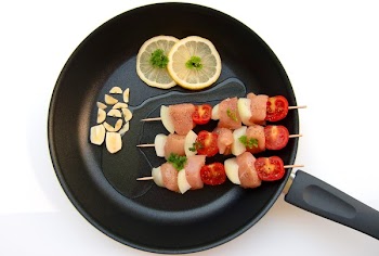 Barbecue Stick Beside Lemon on Black Frying Fan