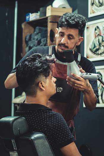 Barber Holding Hair Blower While Stand Beside Man in Black Polo Shirt