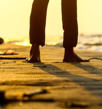 Barefooted Person Standing on Beach Sand