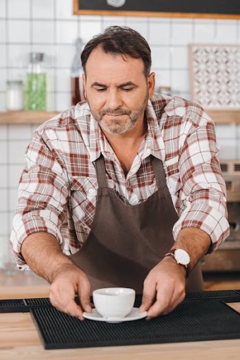 Bartender putting coffee on bar counter