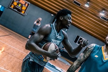 Basketball Player Holding a Brown Ball