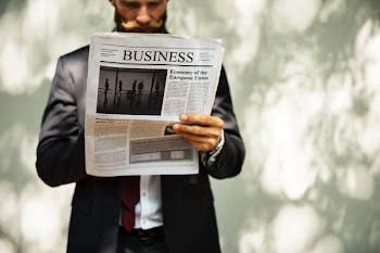 bearded man reading newspaper