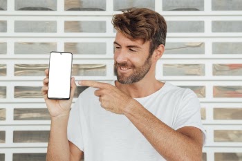 Bearded young man showing smartphone Free Photo