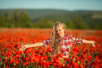 Beautiful blonde girl posing on poppy field