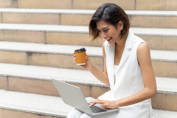 Beautiful cute girl smiling in business woman clothes using laptop computer on urban city Free Photo
