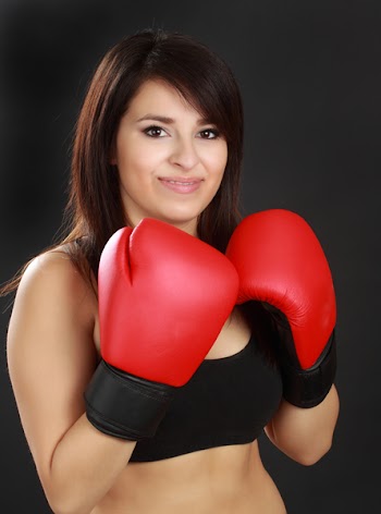 beautiful hispanic woman wearing red boxing glove