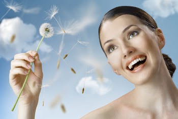 beautiful smiling girl with dandelion in hand