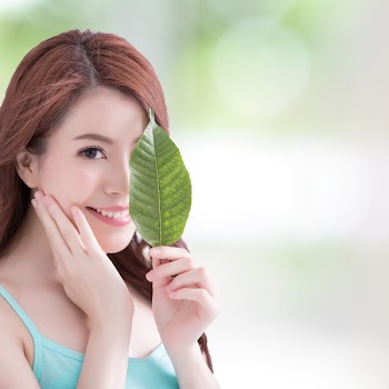 beautiful woman face portrait with green leaf , concept for skin care or organic cosmetics , asian beauty
