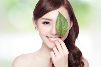 beautiful woman face portrait with green leaf , concept for skin care or organic cosmetics , asian beauty