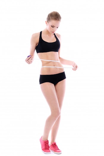 Beautiful woman measuring her waistline Free Photo